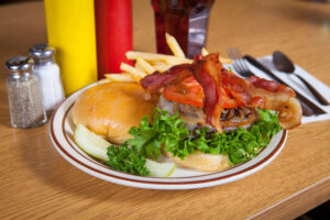 Cheeseburger with bacon, fried onions, lettuce and pickle served with fries from A Pine Restaurant in Pequot Lakes, MN