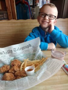 Kid enjoying some chicken, fries and chocolate milk from A-Pine Restaurant in Pequot Lakes, MN