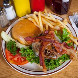 Bacon cheeseburger with grilled onions, tomato, pickle and served with fries from A Pine Restaurant in Pequot Lakes, MN