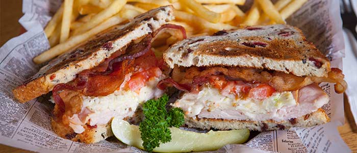 Club sandwich with fries and a pickle from A Pine Restaurant in Pequot Lakes, MN